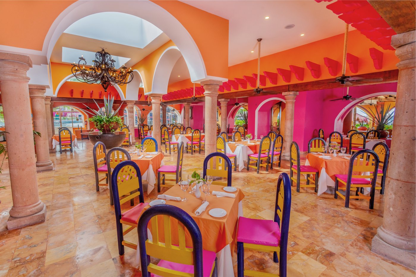 Grand Oasis Palm hotel restaurant with colorful chairs.