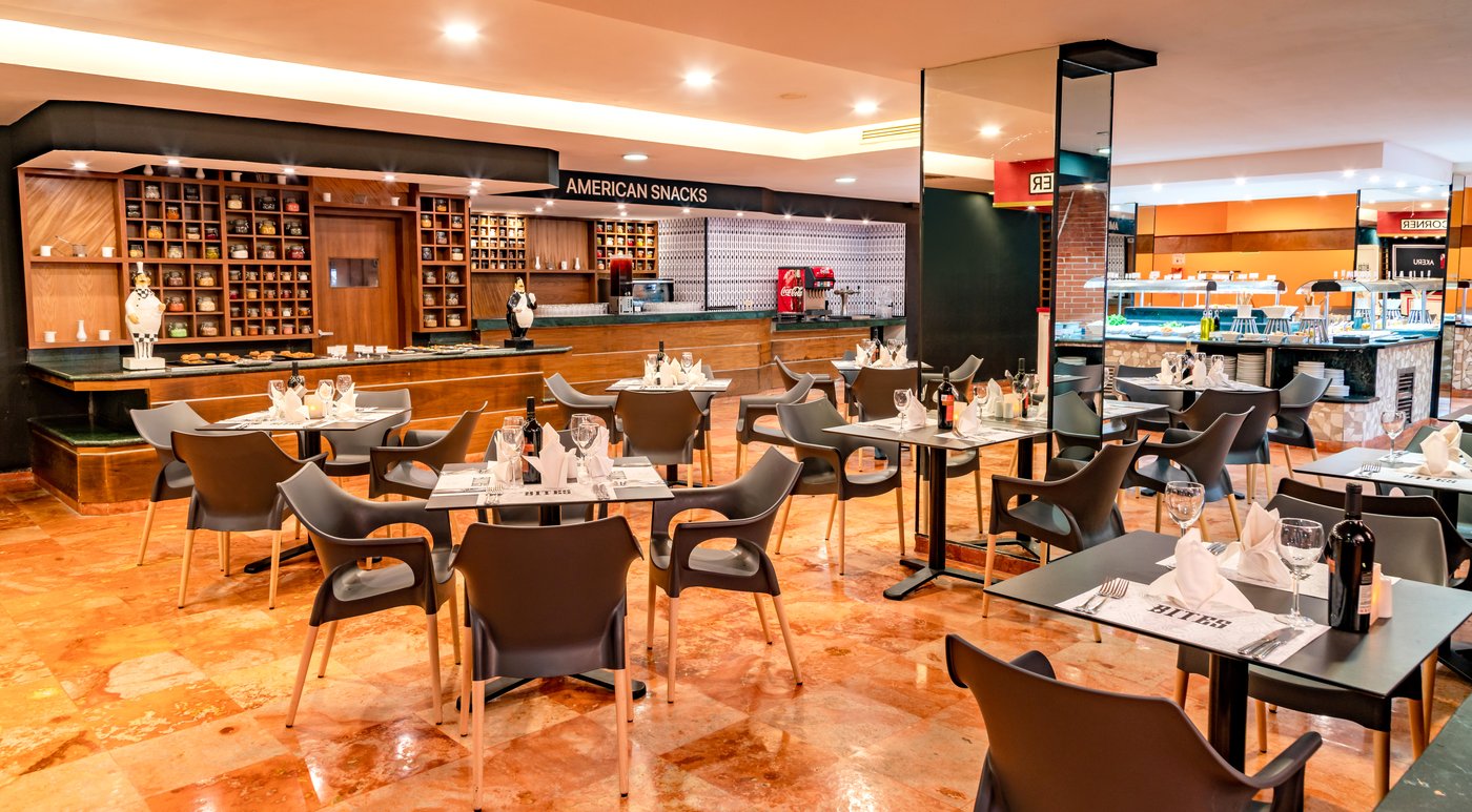 Dining room of a restaurant at the hotel Grand Oasis Palm with a bookshelf.