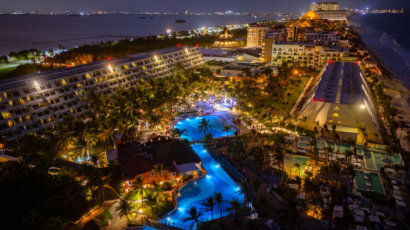 Galeria de Panorámico: Vista nocturna de las piscinas do hotel Grand Oasis Cancun.