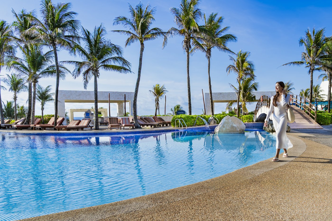 Persona caminando en el área de piscina de Grand Oasis Cancun.