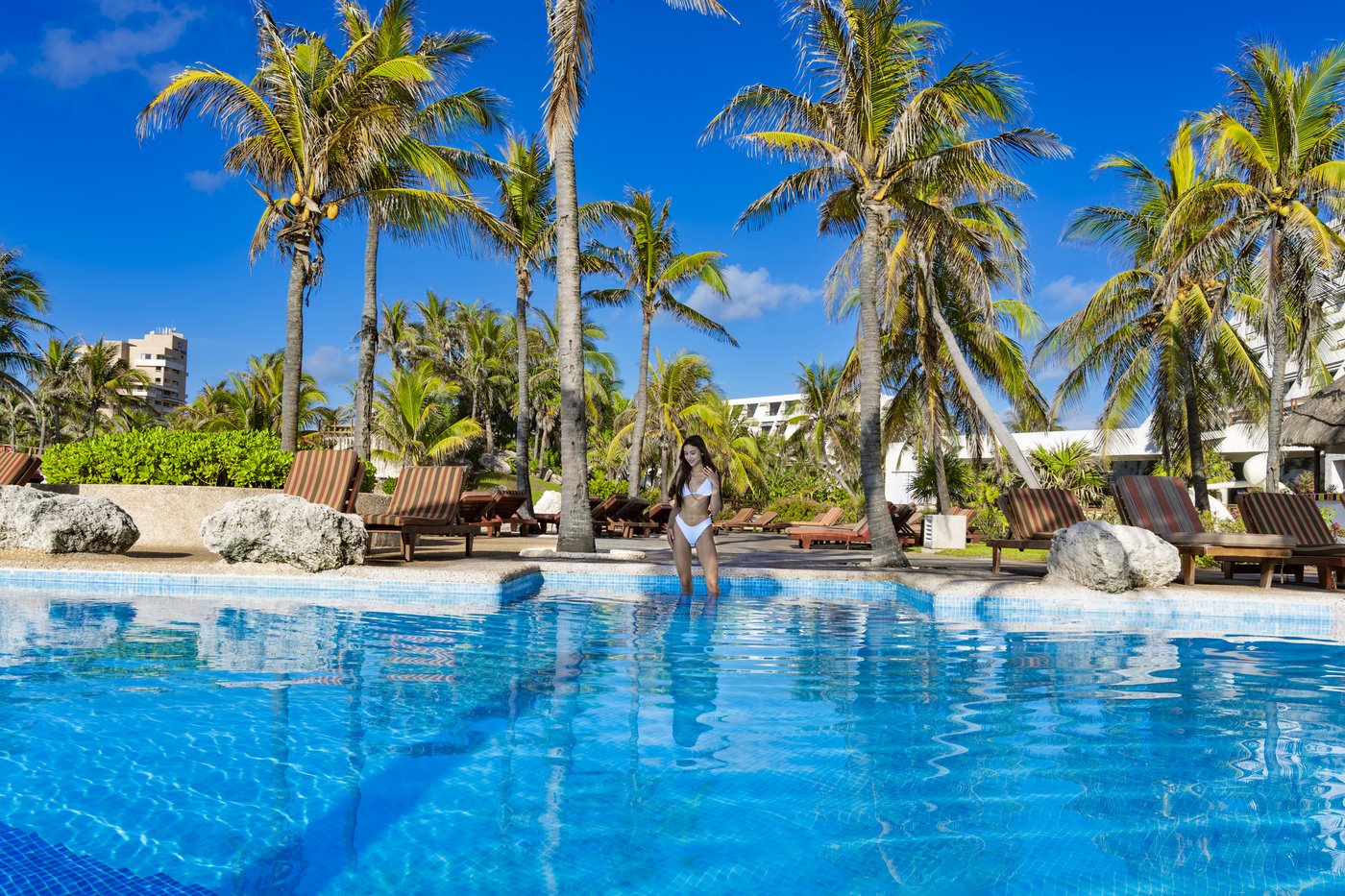 Piscina de Grand Oasis Cancun com puente e cascada.