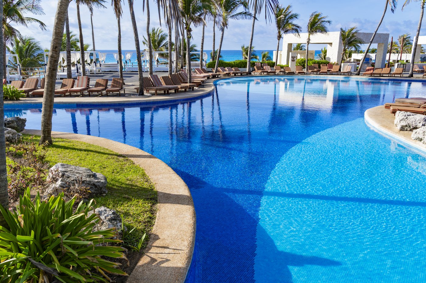 Huéspedes relajándose en una piscina de Grand Oasis Cancun.