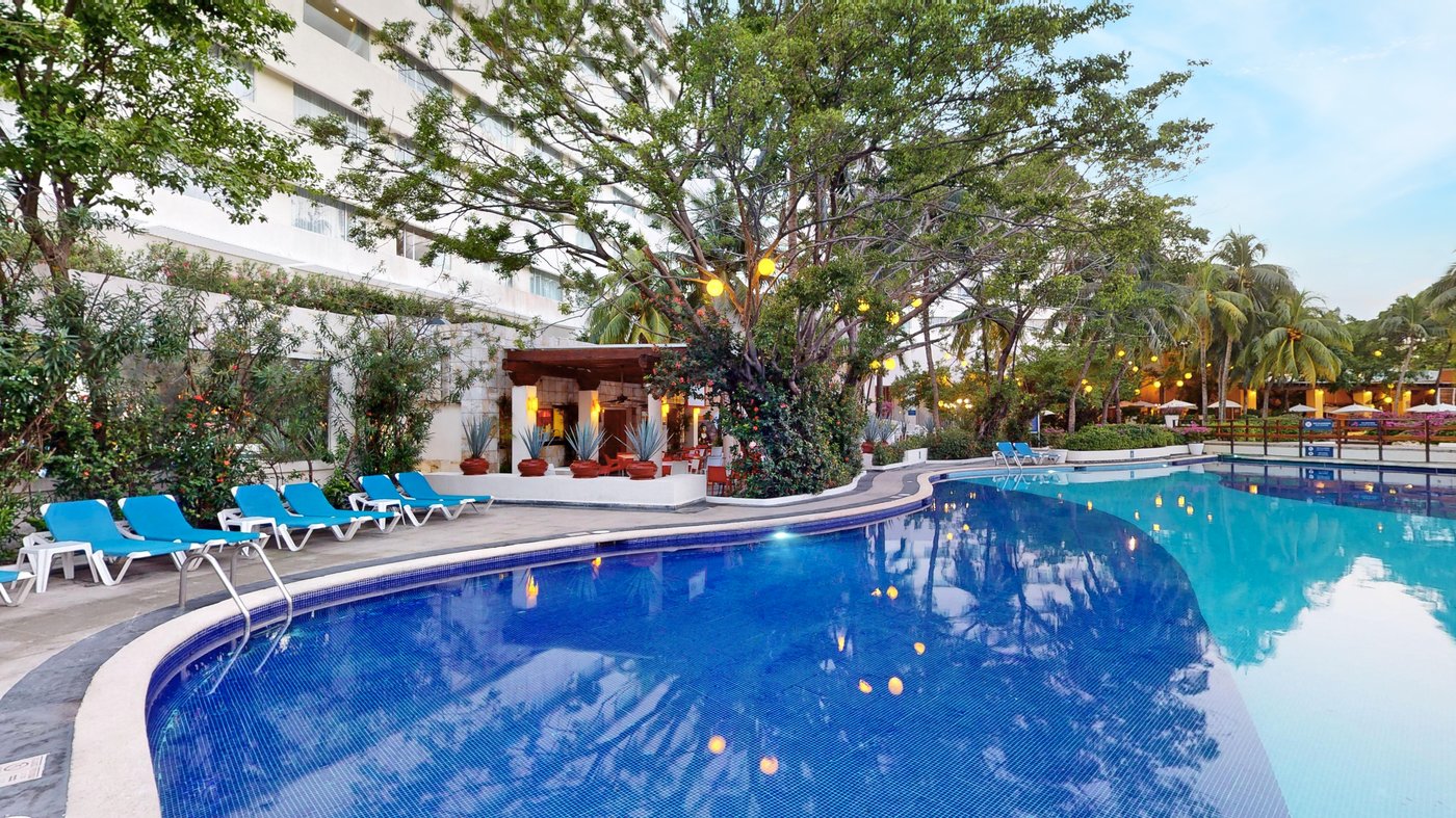 Galeria de Piscina: Piscina principal do hotel Grand Oasis Palm rodeada de palmeras.