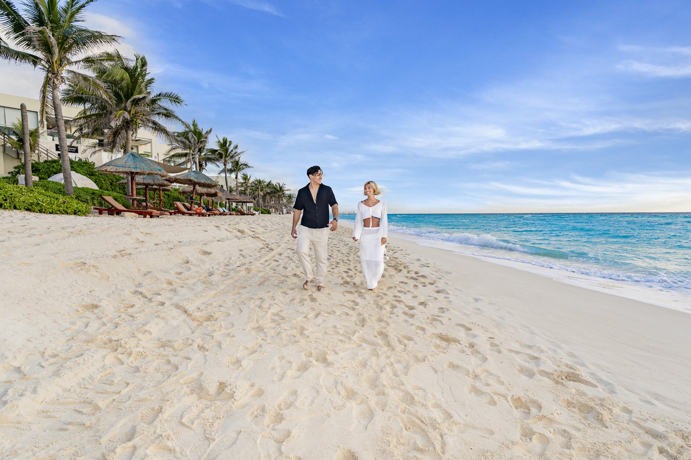 Galeria: Pareja recién casada caminando por la praia de arena blanca do hotel The Pyramid Cancun.