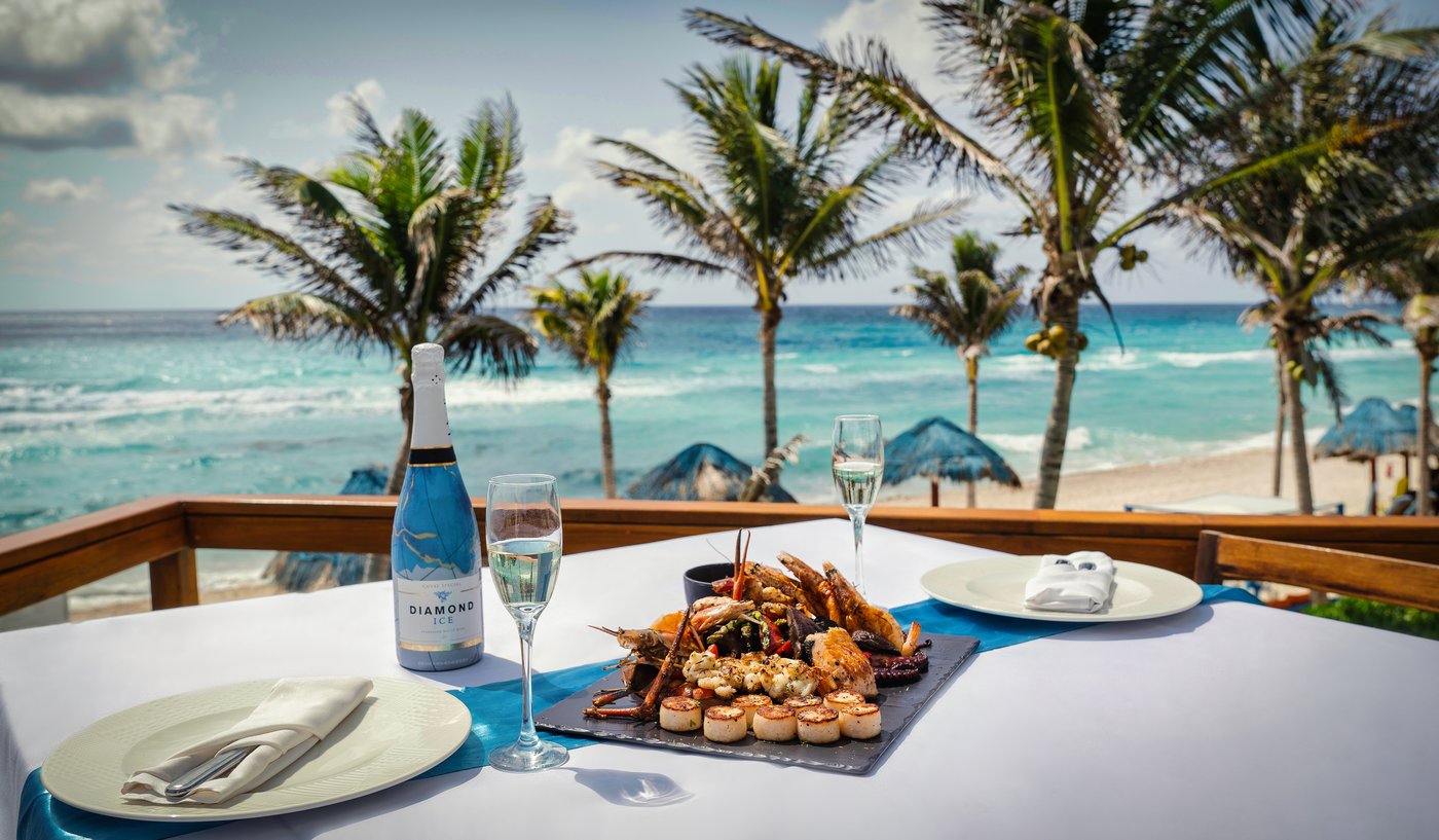 Galeria: Platos de mariscos en un restaurante al aire libre do hotel The Pyramid Cancun com vista para o mar.