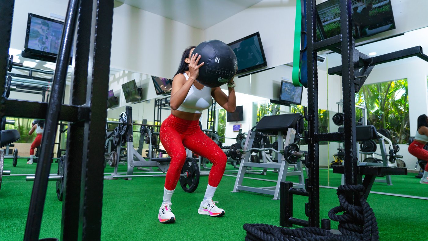 Persona haciendo ejercicio com pesas en el gimnasio do hotel The Sens Cancun.