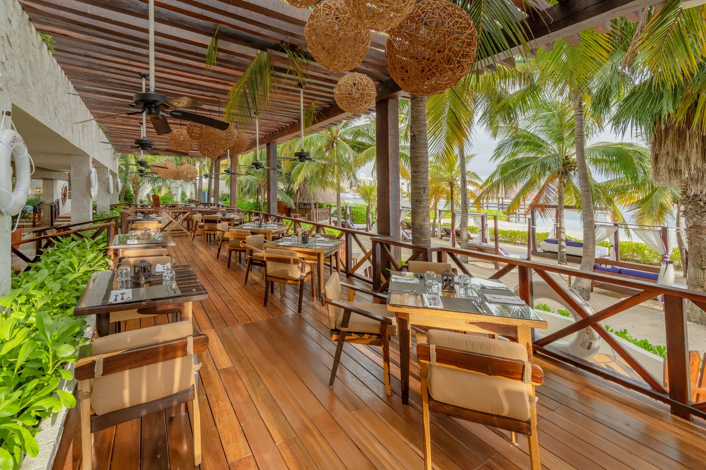 Bar com taburetes de madera e un ambiente vibrante en The Sens Cancun.