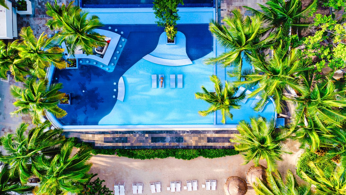Persona nadando en una de las piscinas do hotel The Sens Cancun.