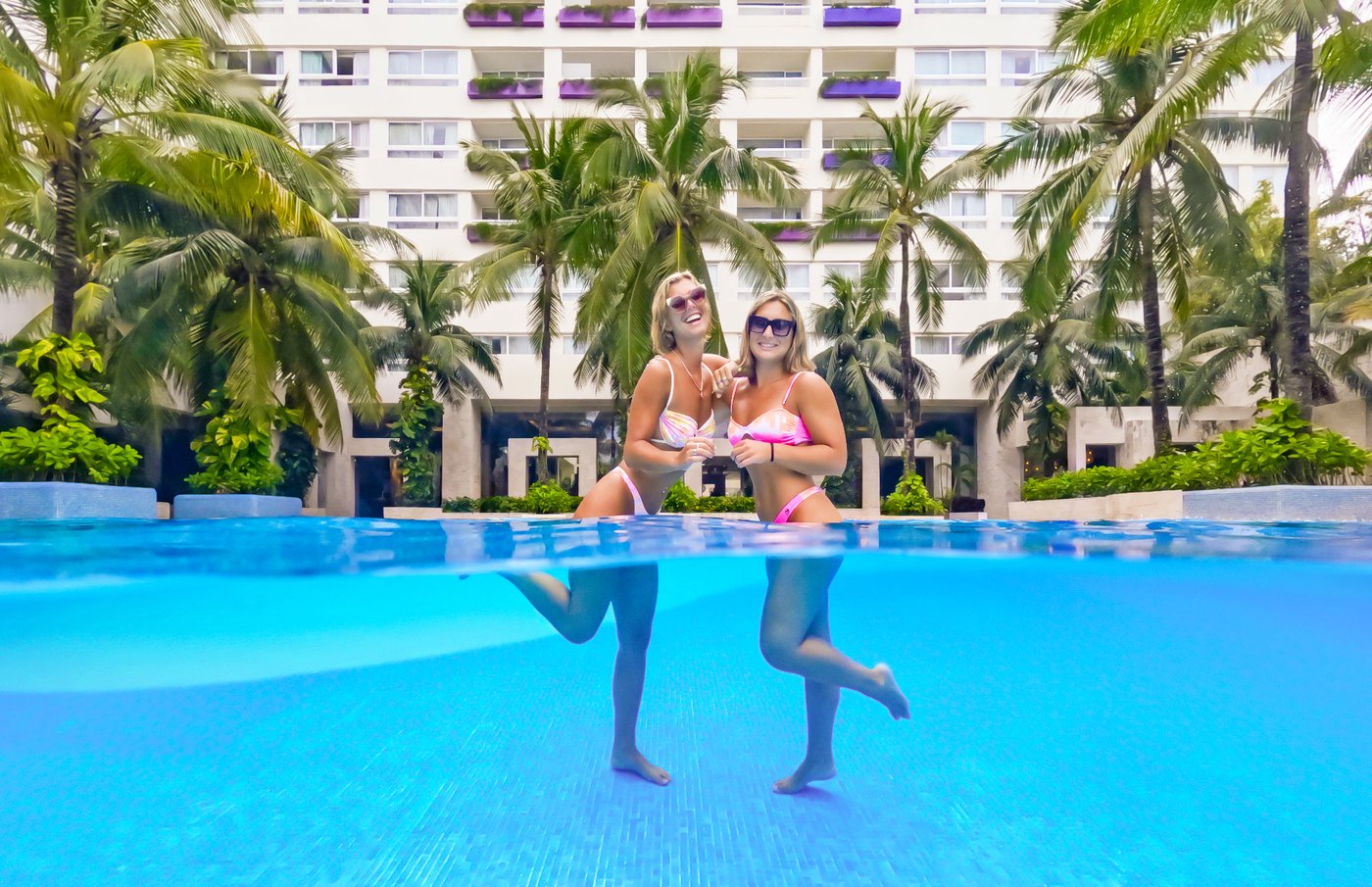 Huésped saltando a la piscina no hotel The Sens Cancun.
