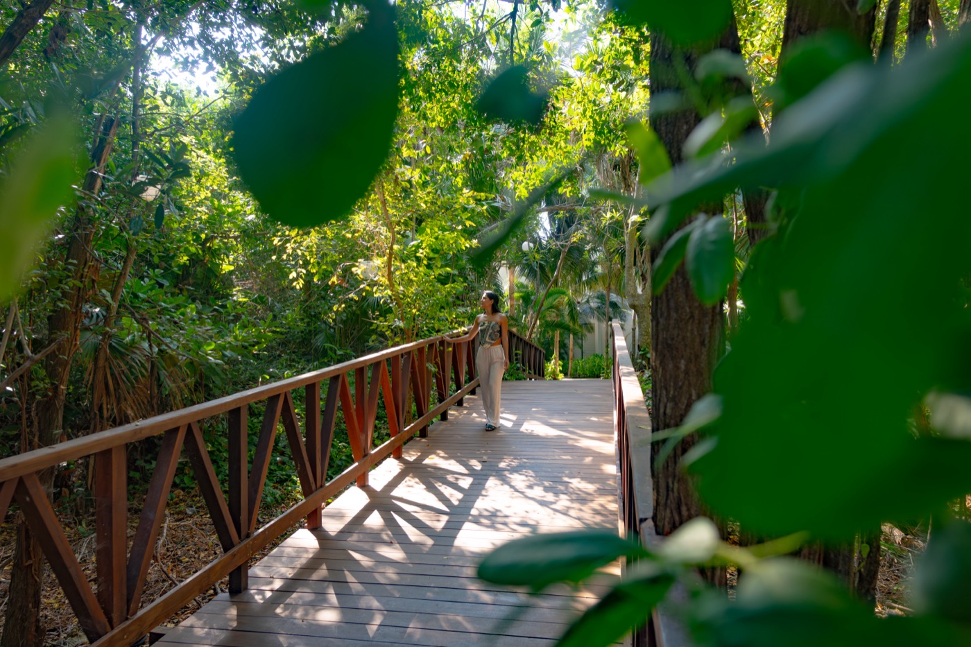 Huésped en un puente de madera do hotel Grand Oasis Tulum Riviera.