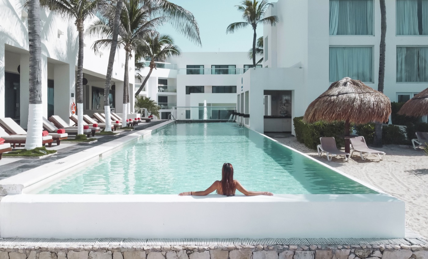 Galeria de Piscina: Huésped caminando al borde da piscina do hotel The Sens Tulum Riviera.