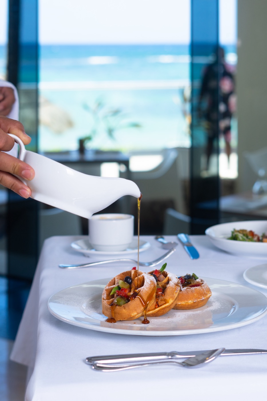 Galeria de A&B: Mano de camarero sirviendo un plato no hotel The Sens Tulum Riviera.